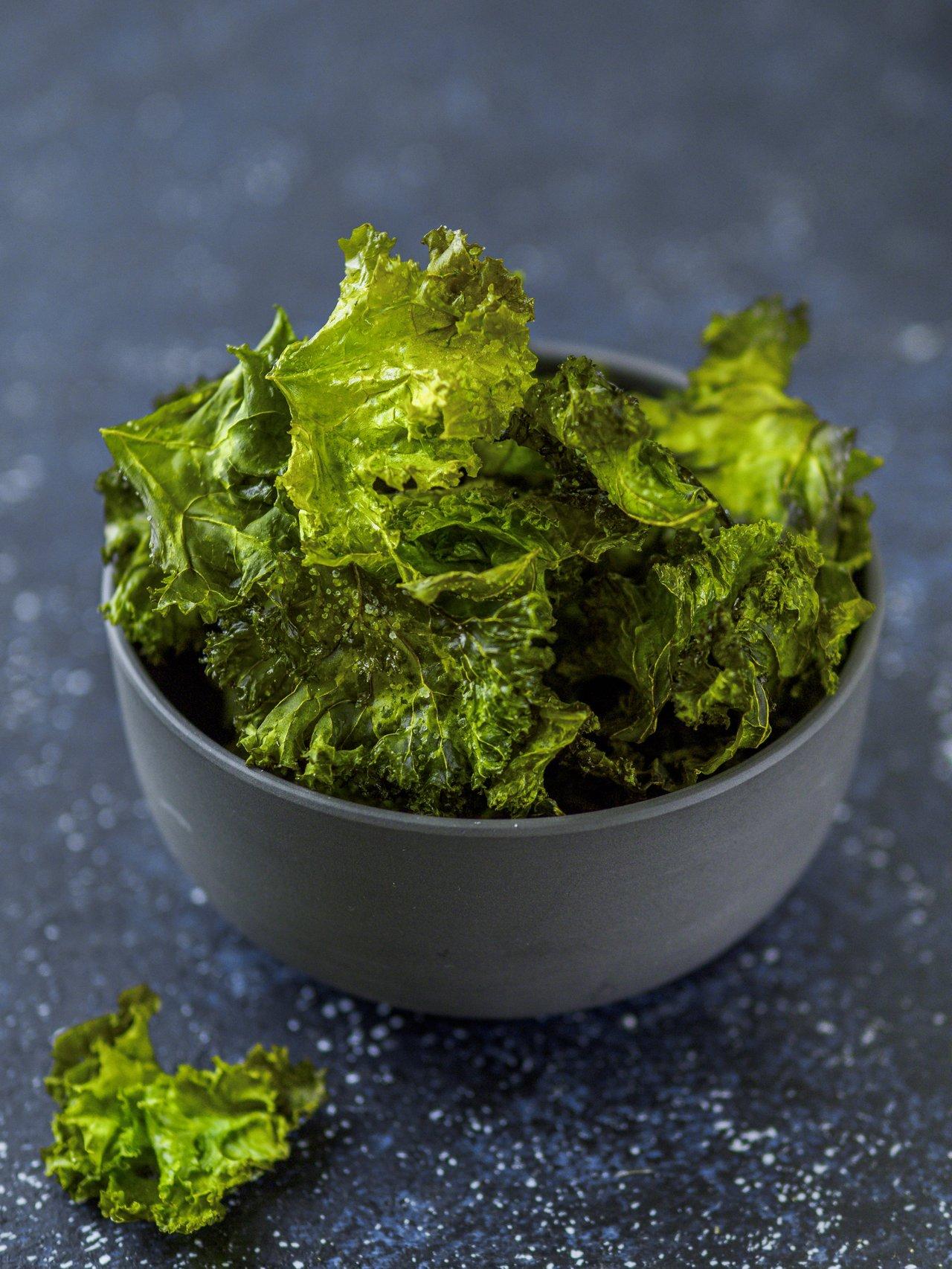 Assiette de chips de chou kale maison croustillantes, parfaites pour un snack sain au bureau.