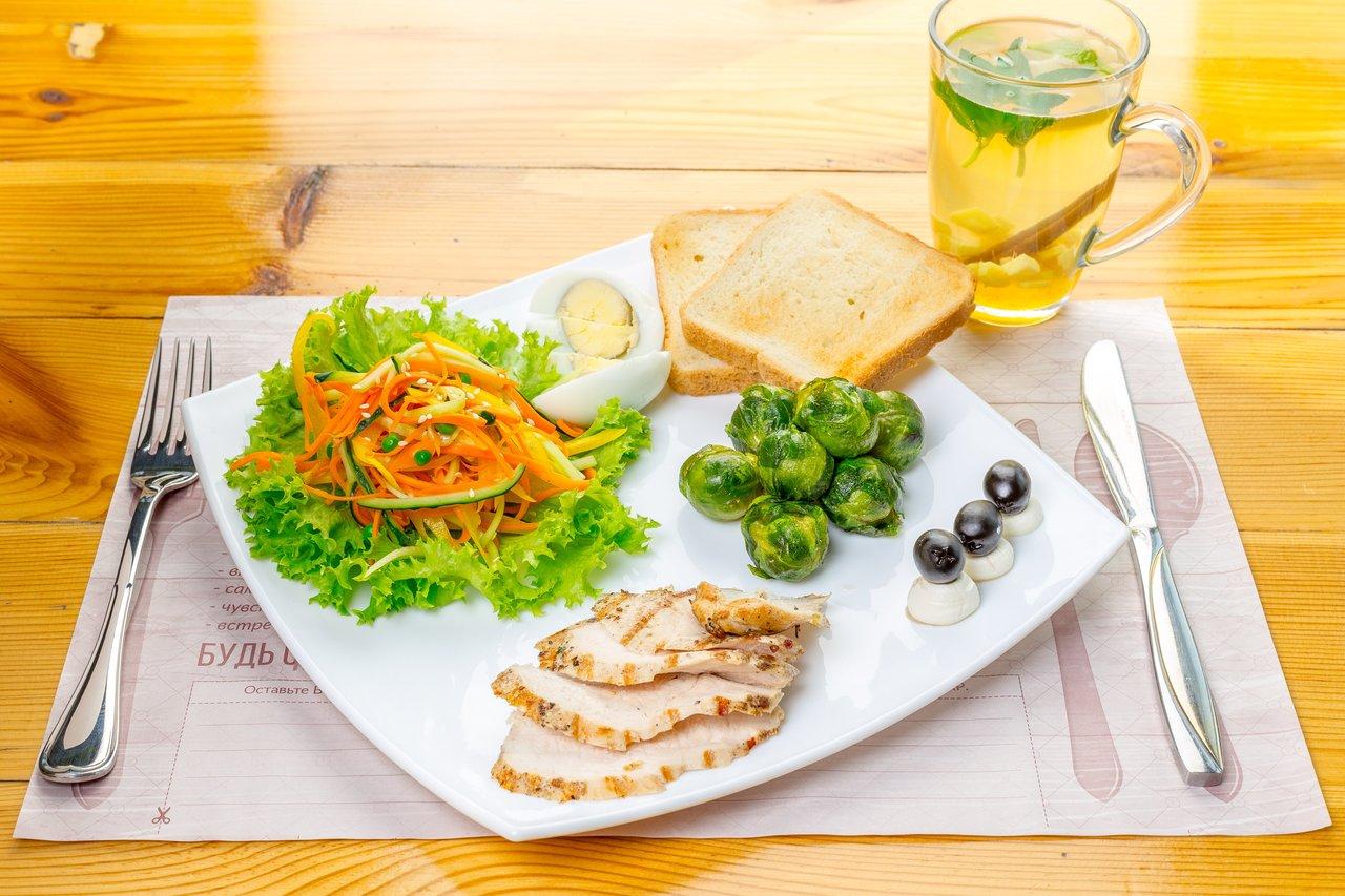 Assiette équilibrée et saine avec poulet grillé, légumes colorés et huile d'olive pour un déjeuner nutritif.