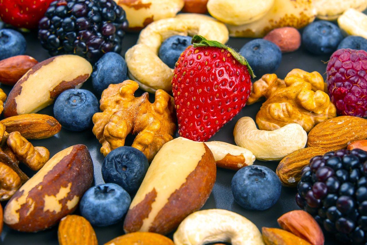 Assortiment de noix et baies fraîches, parfait pour une healthy snack variety au travail.