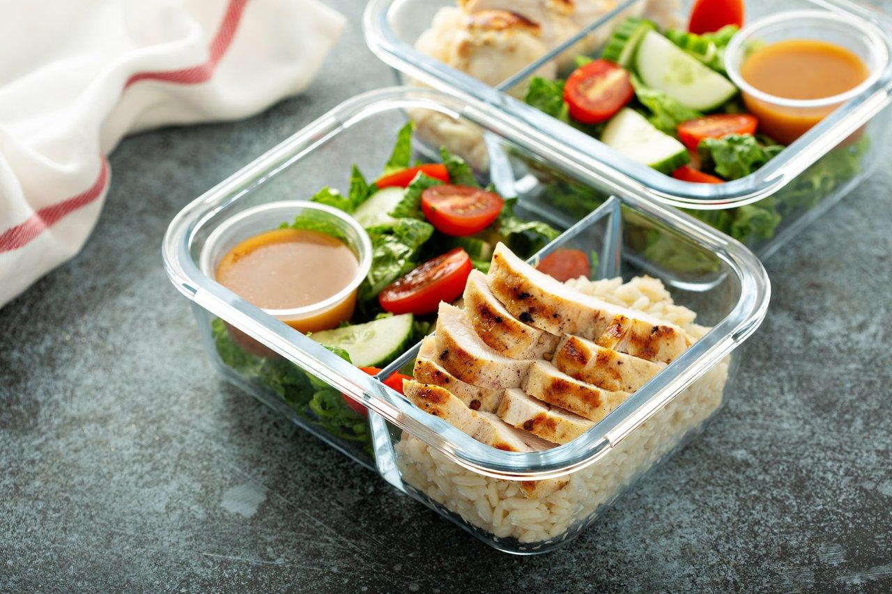 Boîtes hermétiques avec meal prep containers, contenant du poulet grillé et des légumes frais pour une organisation efficace.
