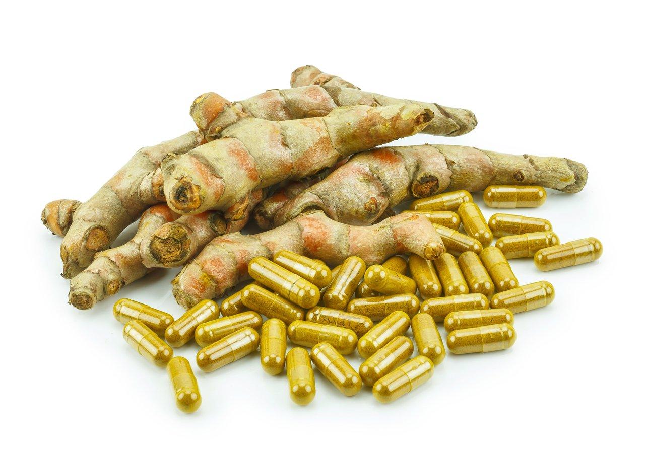 Capsules de curcuma Longvida naturelles entourées de racines de curcuma, symbolisant efficacité et tradition.