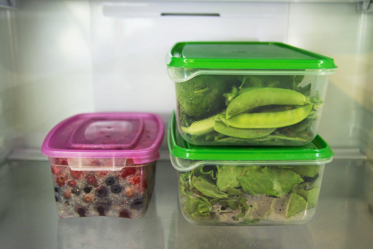Contenants de meal prep avec légumes frais et fruits dans le frigo, pour des repas de la semaine organisés.