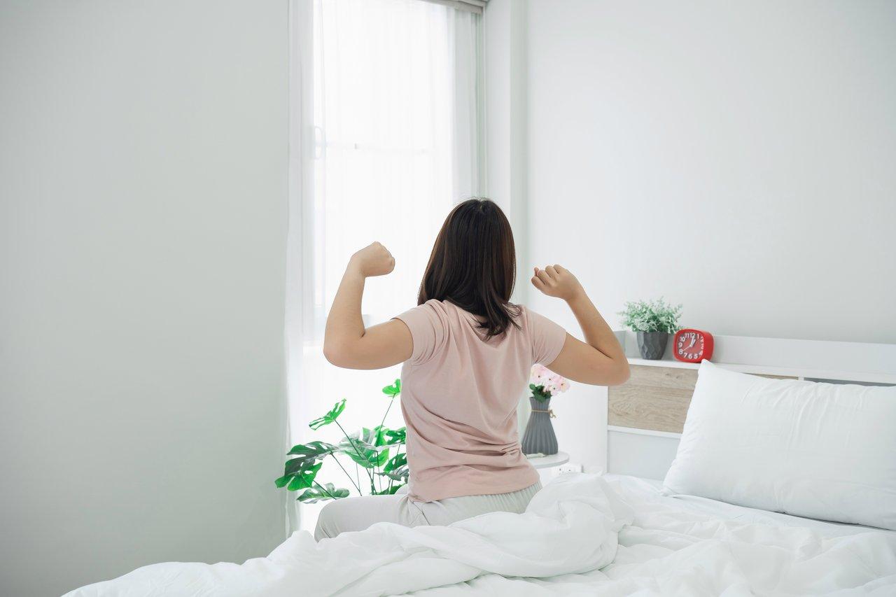 Étirements doux dans une chambre lumineuse, parfaits pour une routine matinale axée sur le bien-être.
