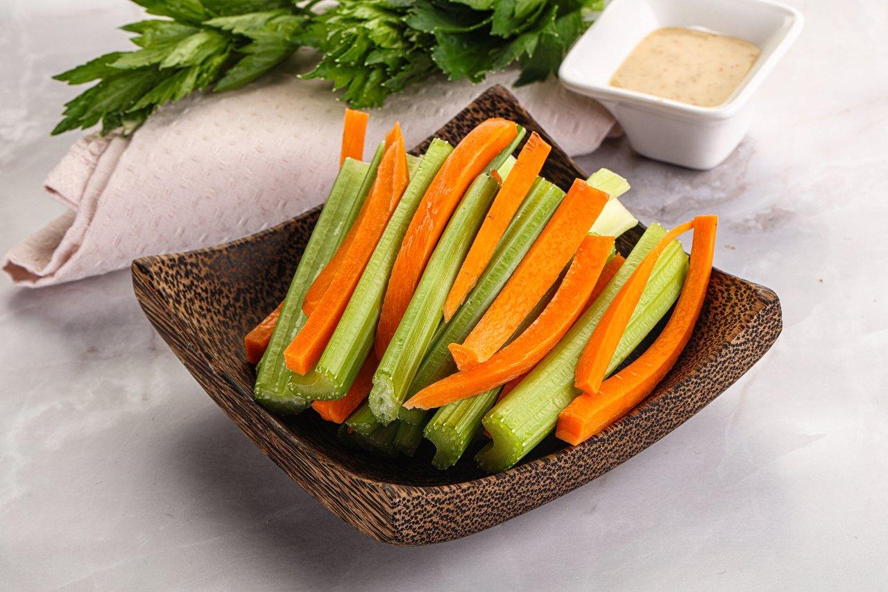 Plateau de bâtonnets de légumes bio colorés avec des labels naturels, illustrant leur fraîcheur et leur qualité nutritionnelle.