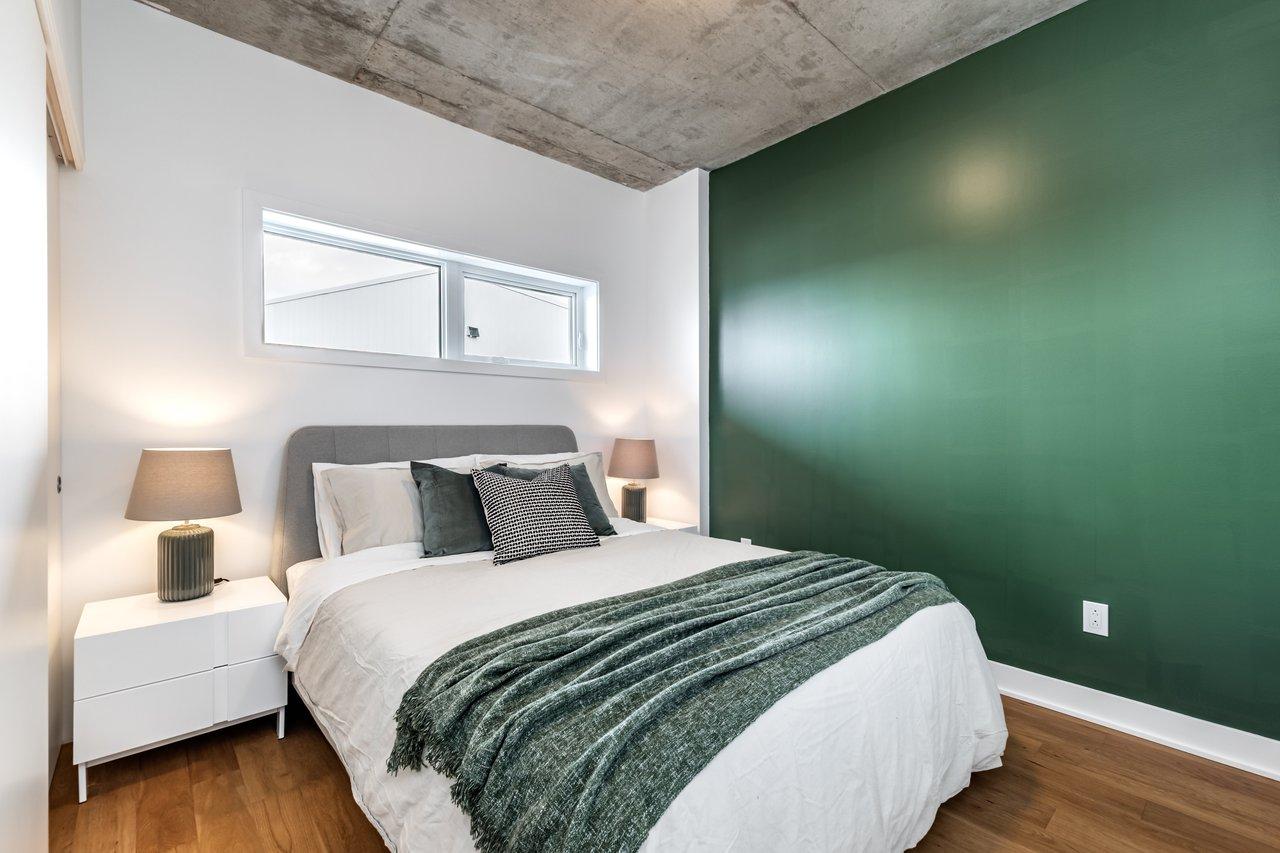 Pot de peinture écologique sans COV dans une chambre lumineuse aux murs verts, idéale pour un intérieur sain.