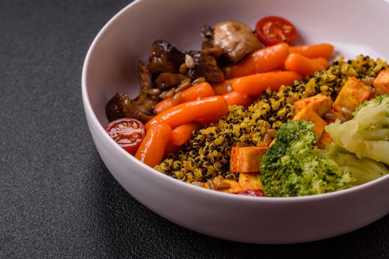 Un bol végétarien coloré avec tofu, brocoli, quinoa et champignons, idéal pour un repas sain et équilibré.