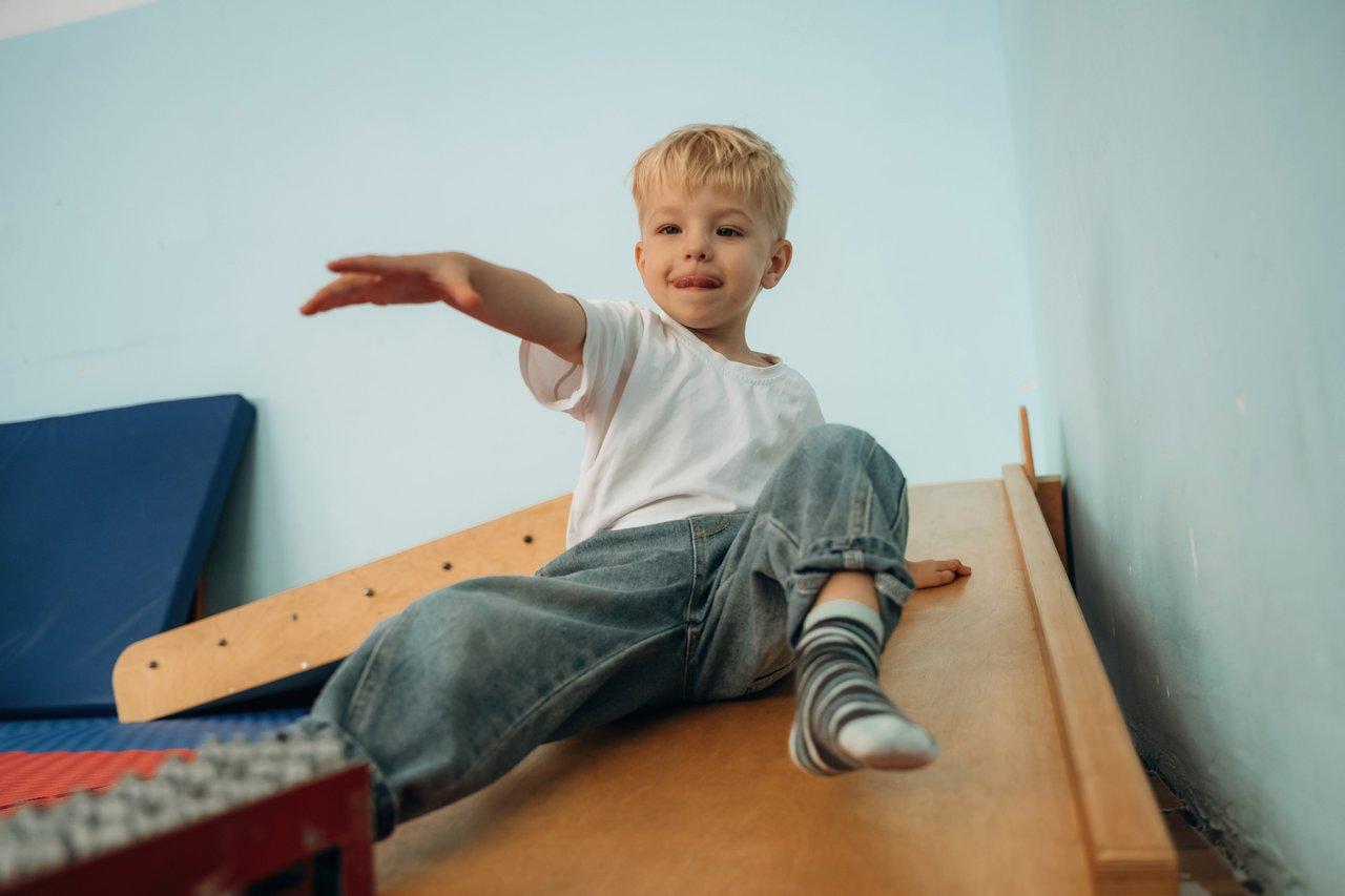 Un enfant jouant dans une chambre lumineuse équipée d’un mobilier en bois massif certifié FSC pour une ambiance naturelle.
