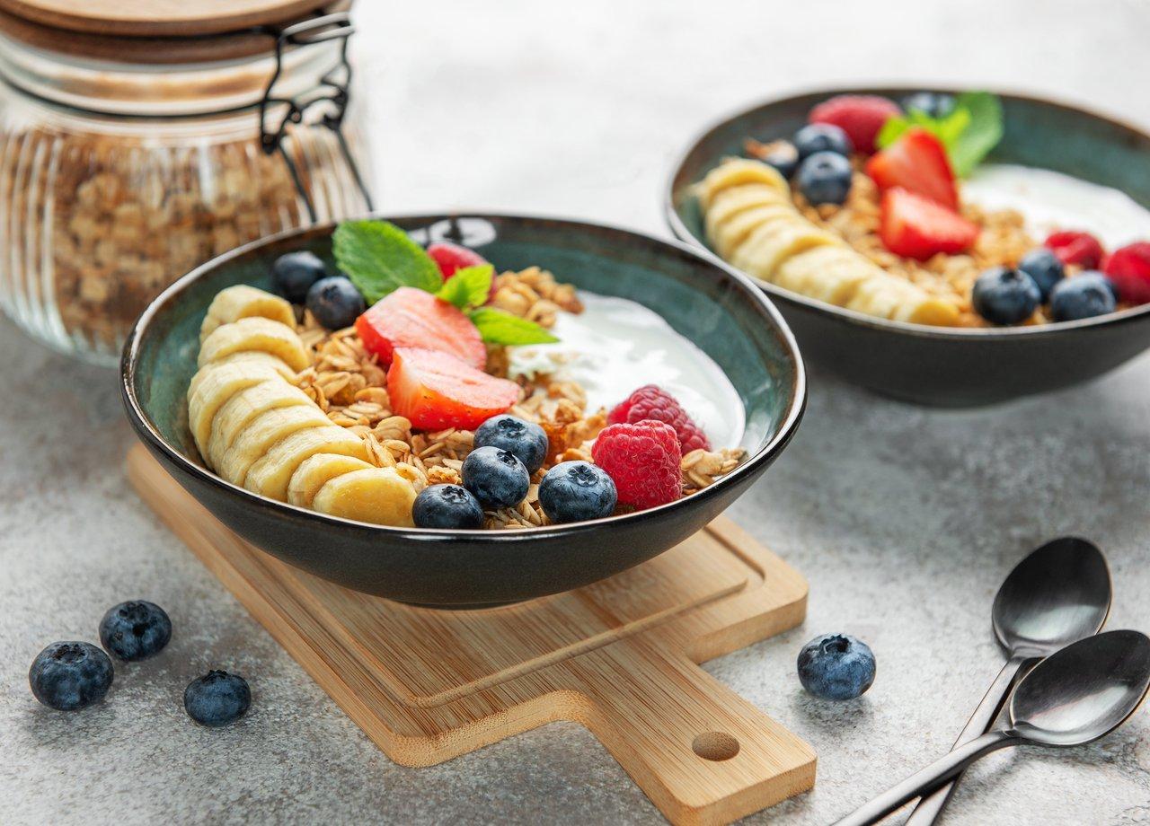 Un healthy breakfast bowl composé de yaourt, granola, fruits frais et noix pour un début de journée équilibré.
