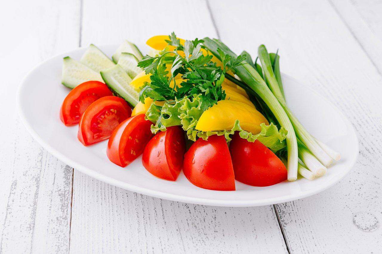Une assiette équilibrée avec une moitié de légumes colorés crus et cuits, pour atteindre l'apport recommandé.