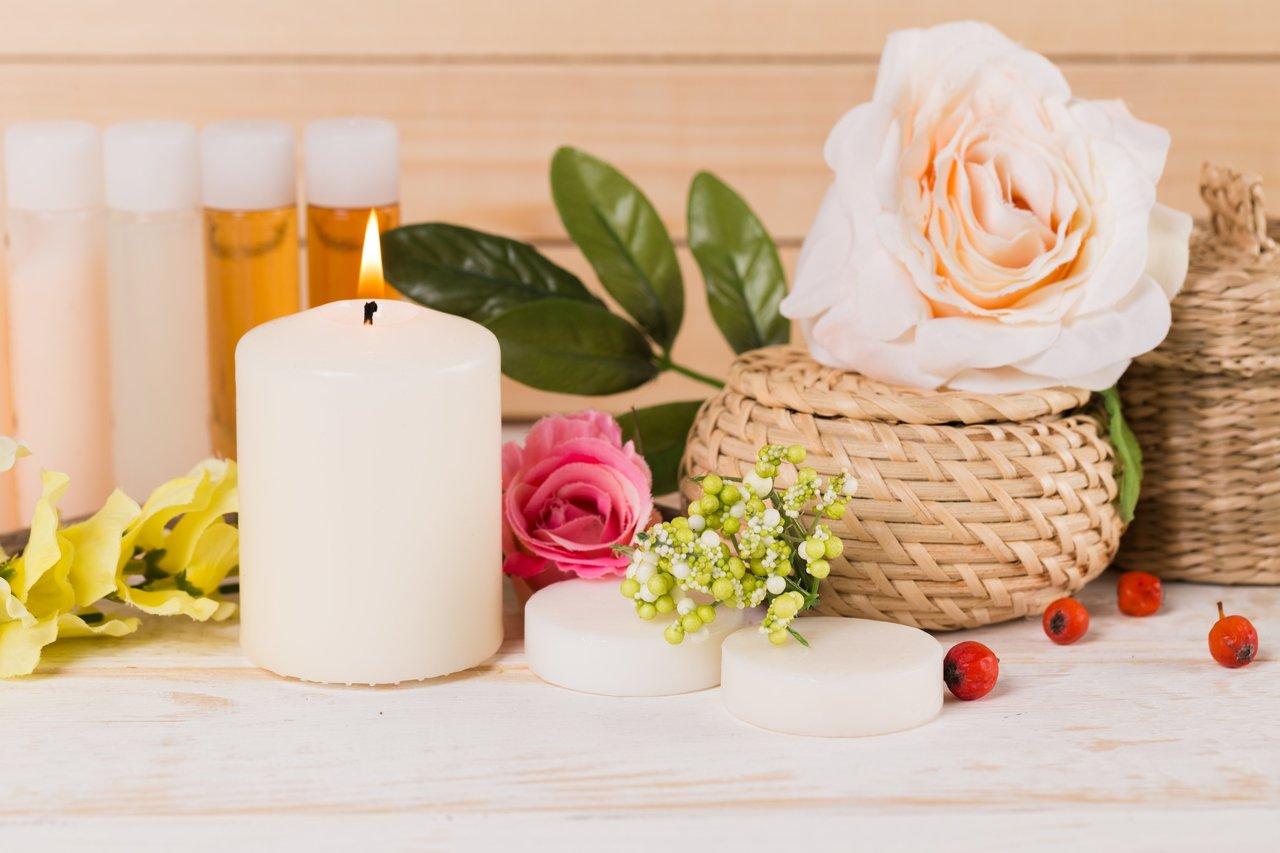 Une bougie allumée et une huile essentielle créent une ambiance de relaxation propice à l’aromathérapie.