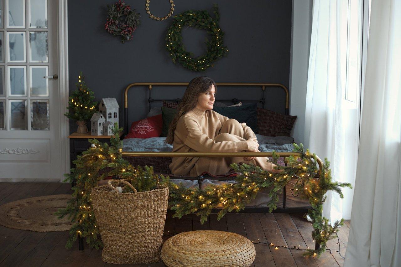 Une chambre cosy d'hiver avec lumière tamisée, diffuseur d'huiles essentielles et plaid chaud.