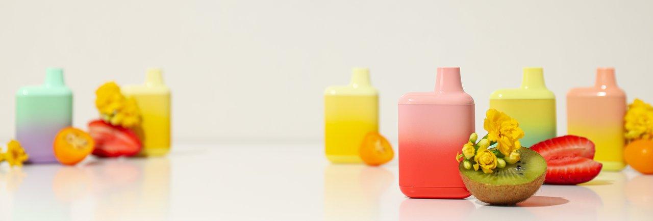 Une gourde colorée sur un bureau avec des fruits frais pour une hydratation optimale au travail.