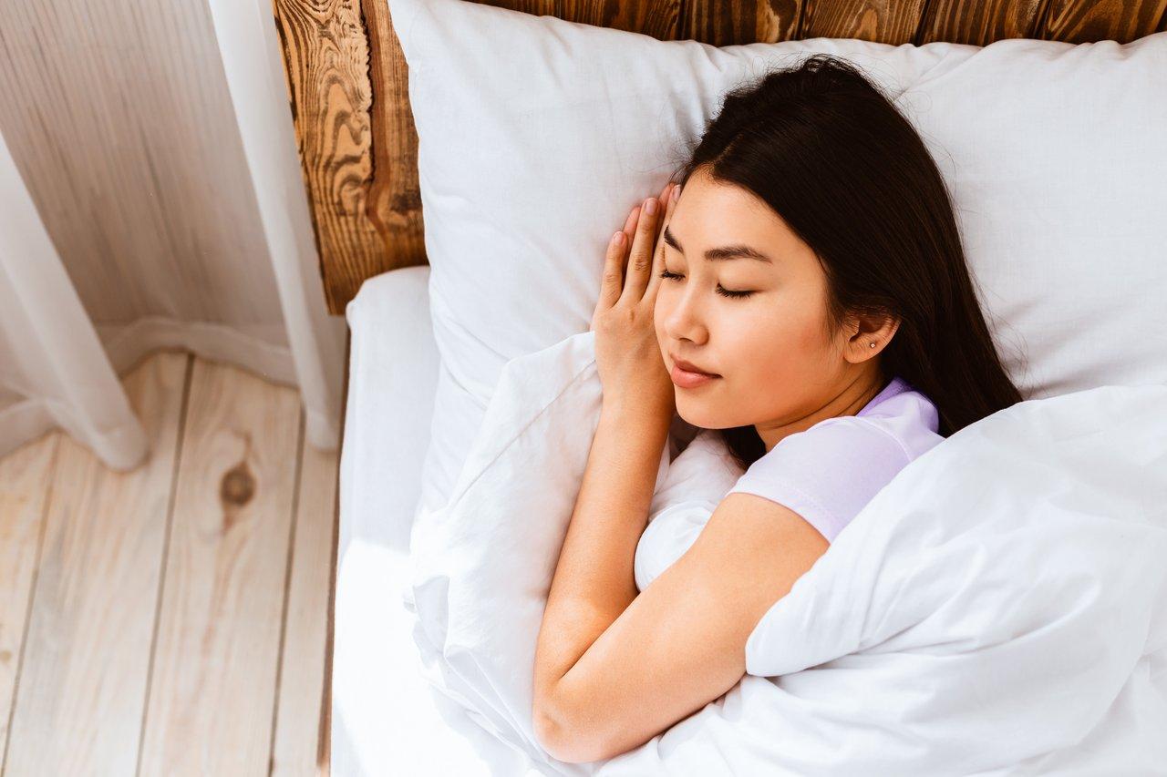 Une personne dormant paisiblement avec des bouchons d’oreilles pour un sommeil réparateur et calme.