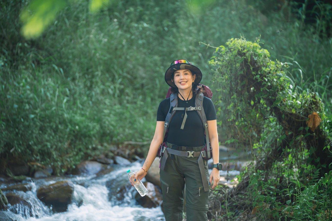 Une personne souriante en pleine nature, illustrant la gestion du stress par la marche en extérieur.