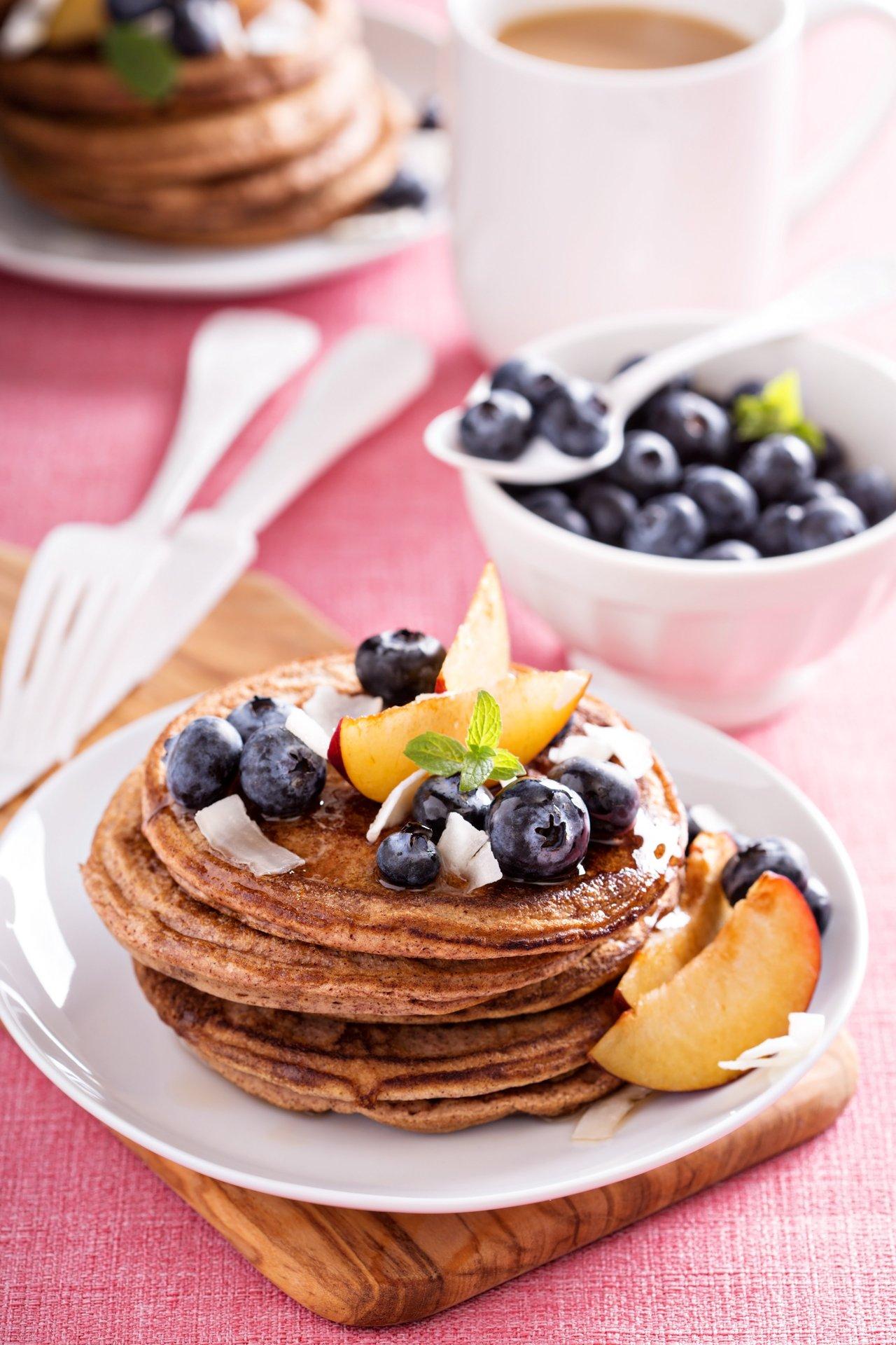 Une pile de healthy cinnamon pancakes stack garnie de fruits frais pour un petit-déjeuner d’hiver réconfortant.